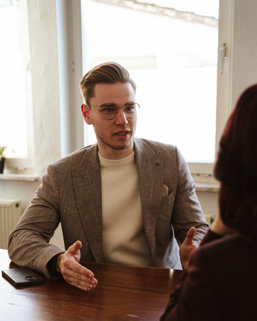 Nicholas Bode im Gespräch mit einer Kundin am Tisch